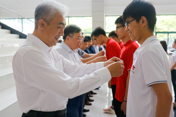 公司党员教师代表为毕业生党员佩戴党员徽章 侯王宇摄 公司党员教师代表为毕业生党员佩戴党员徽章 侯王宇摄